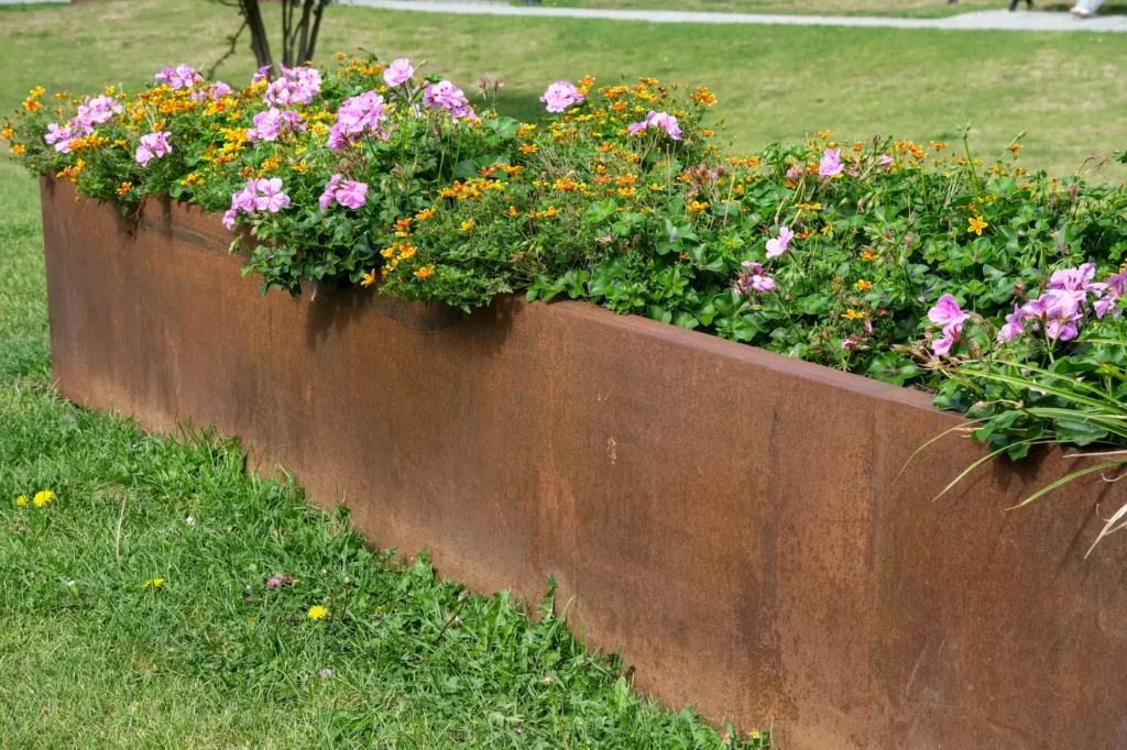 Cortenstalen bloembak in de tuin met verschillende soorten bloemen